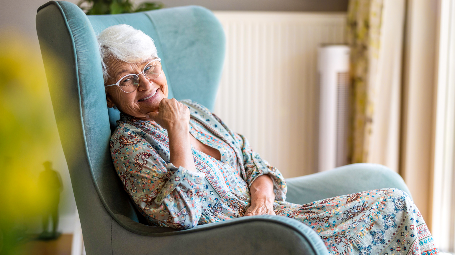 Senior woman relaxing in a comfortable blue chair