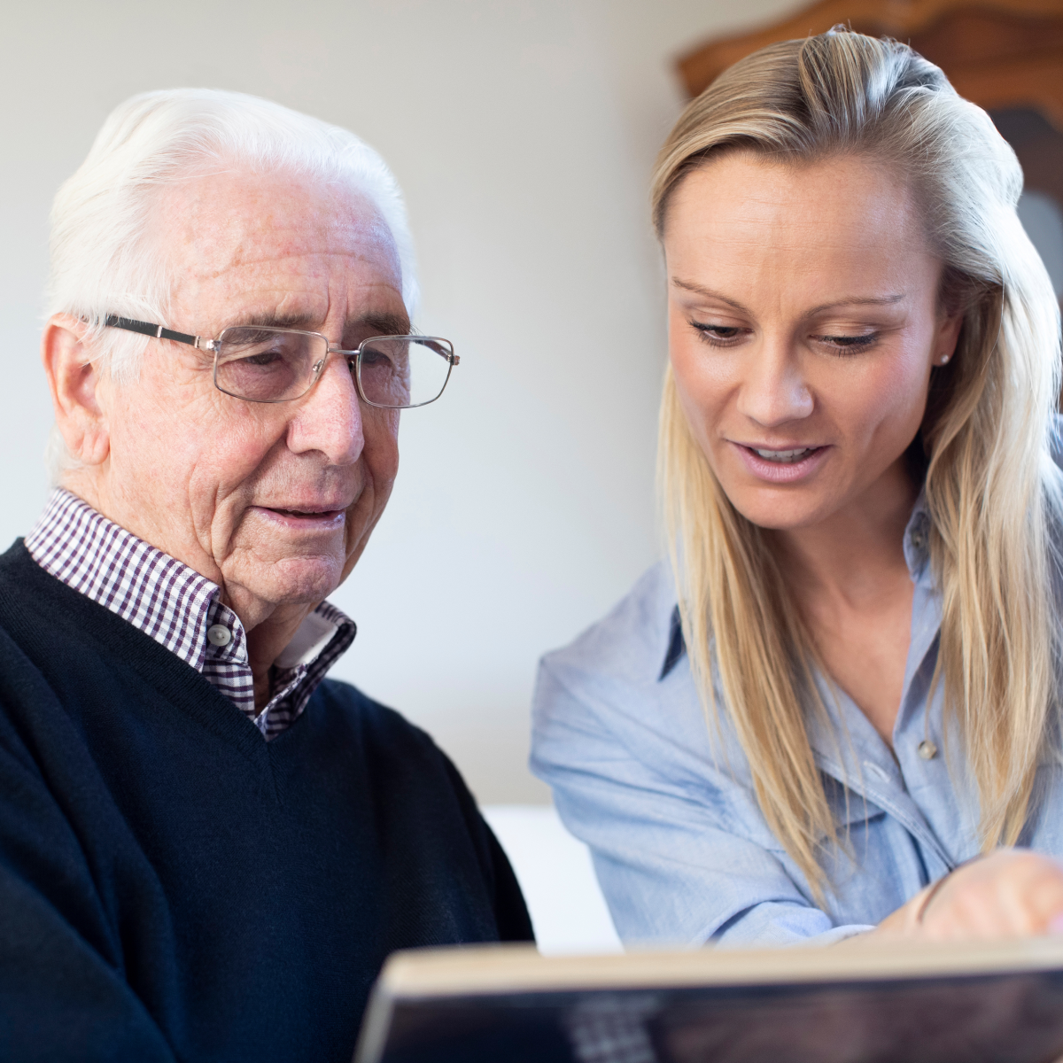 Senior man and relative looking at photos