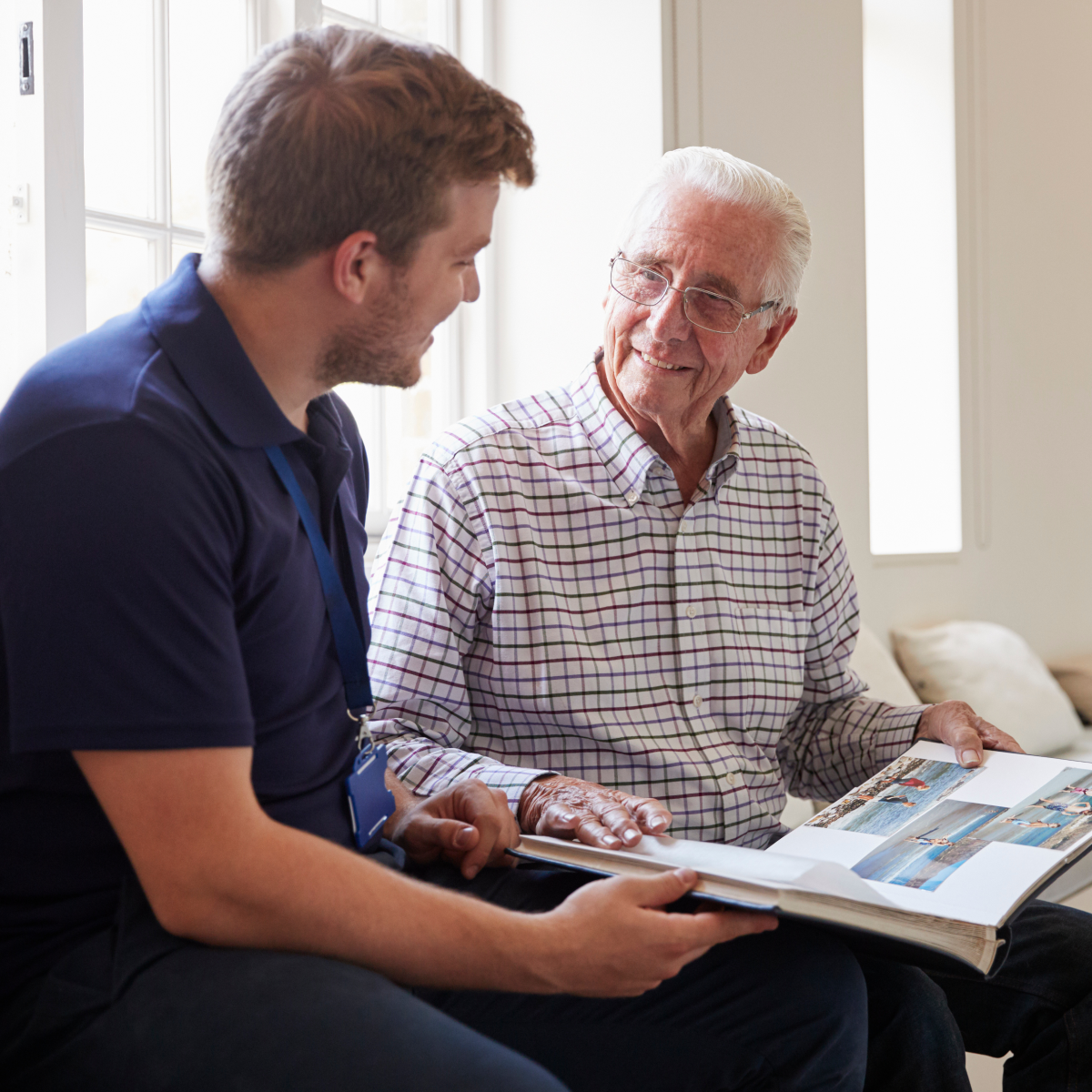 Senior man with caretaker looking at photos
