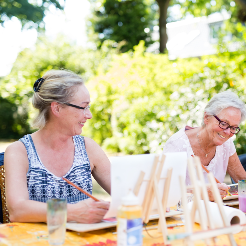 Senior women painting outside